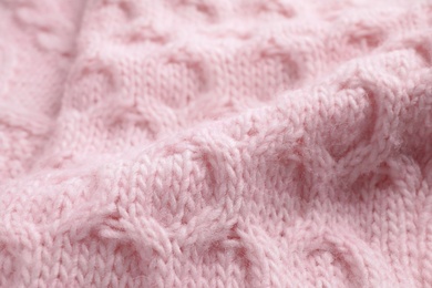 Pink knitted sweater as background, closeup view