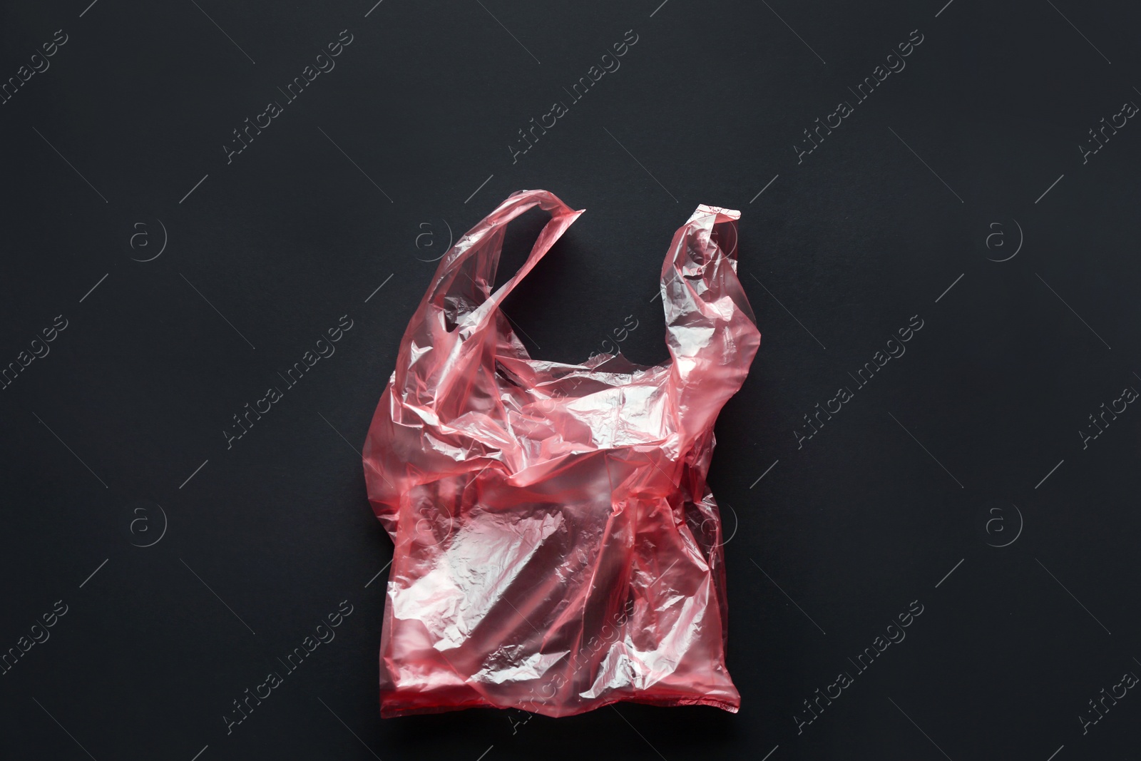 Photo of Clear disposable plastic bag on black background