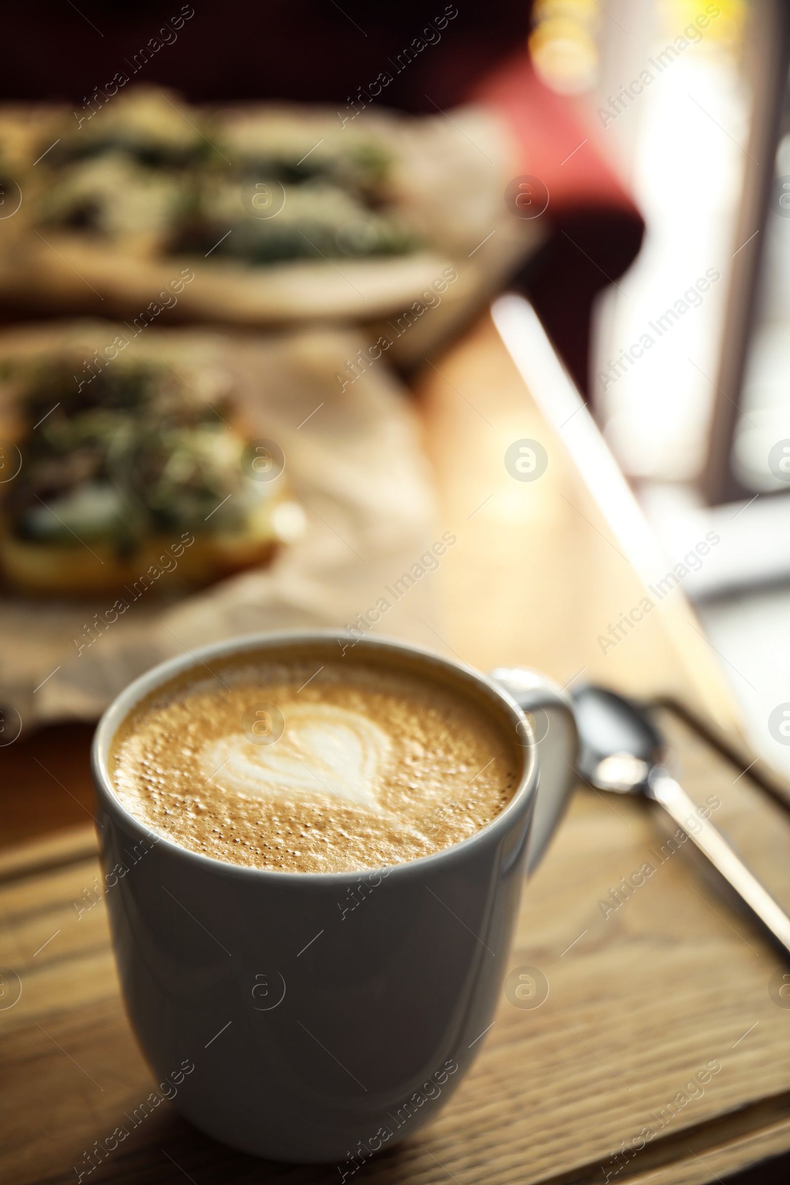 Photo of Cup of delicious coffee on wooden table