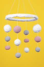 Photo of Cute baby crib mobile on yellow background