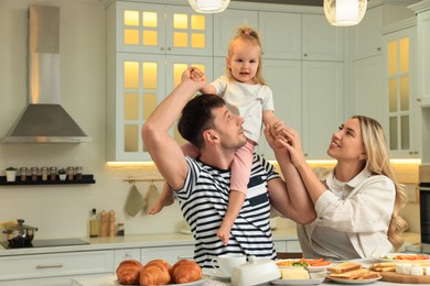 Photo of Happy family having fun during breakfast in kitchen