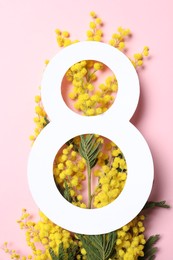 Photo of 8 March greeting card design with yellow mimosa flowers on pink background, top view. Happy International Women's Day