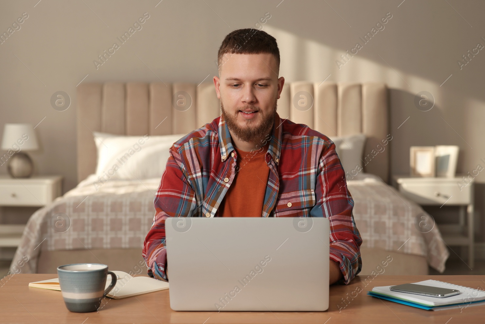 Photo of Online test. Man studying with laptop at home