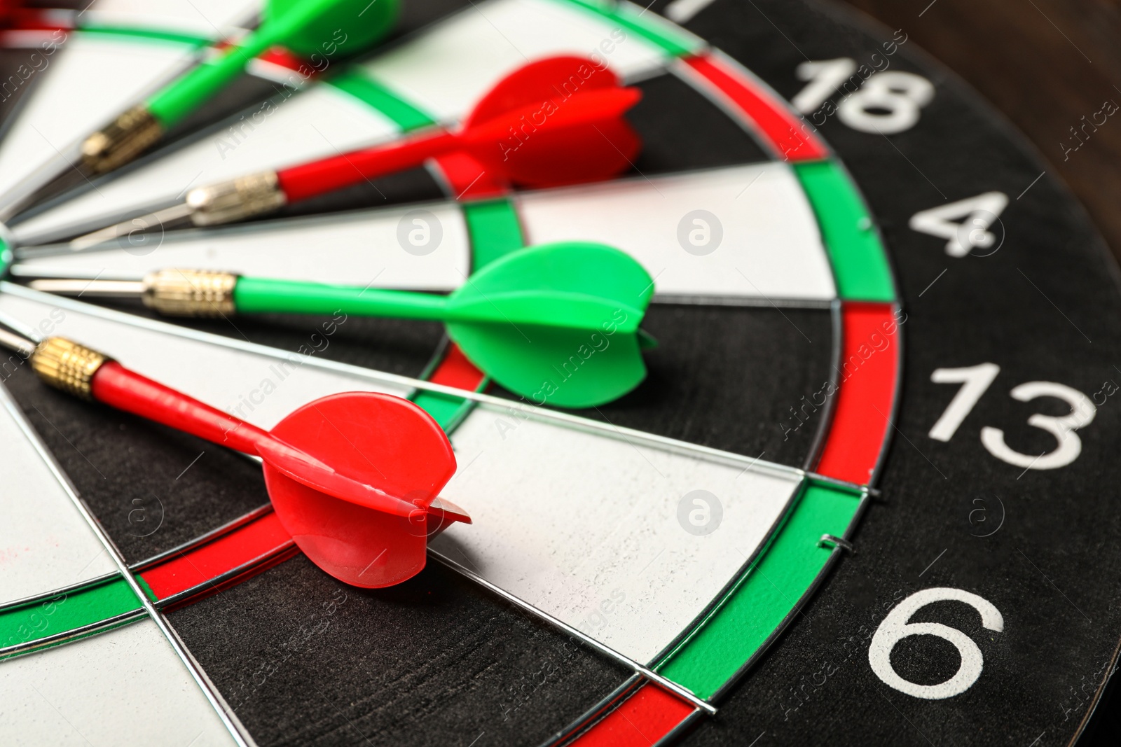 Photo of Red and green arrows on dart board, closeup