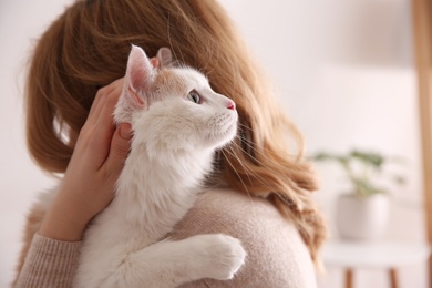 Woman with cute fluffy cat indoors, closeup