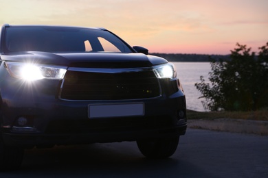 Photo of Modern new car on road near river