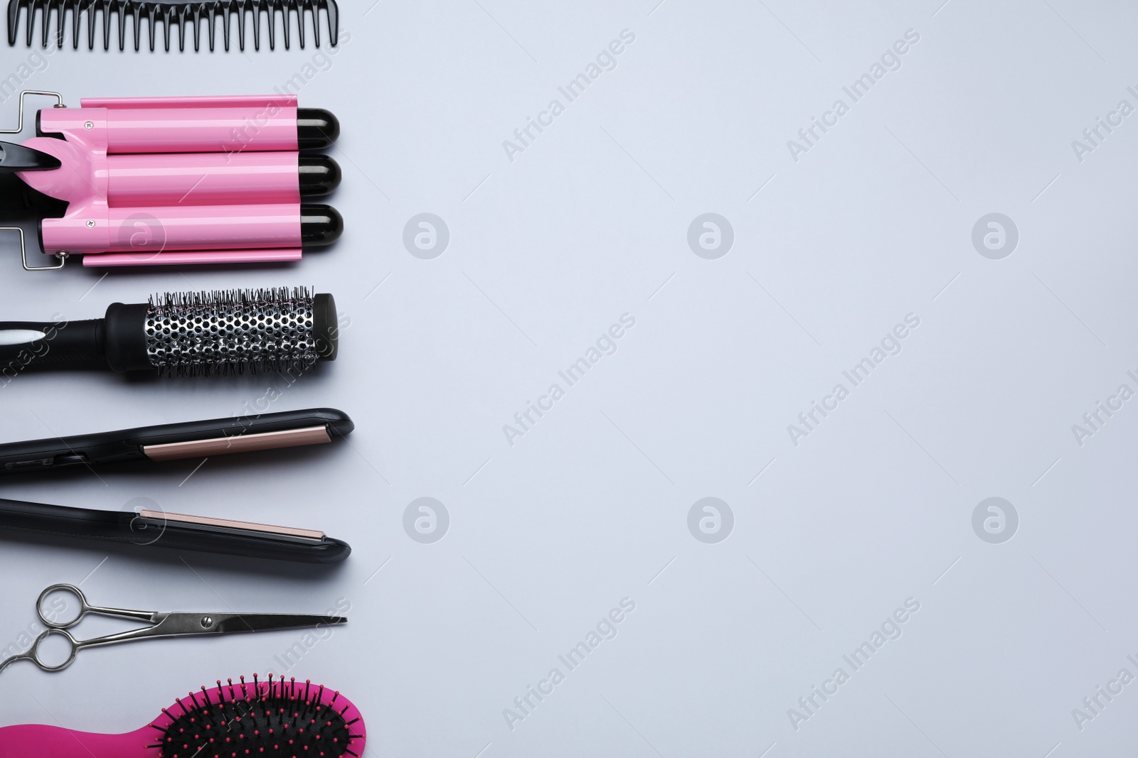 Photo of Flat lay composition of professional hairdresser tools on white background, space for text