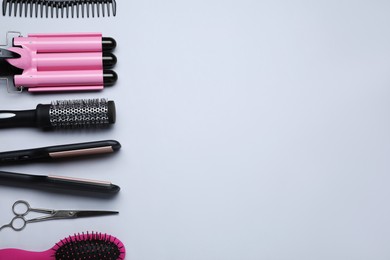 Flat lay composition of professional hairdresser tools on white background, space for text