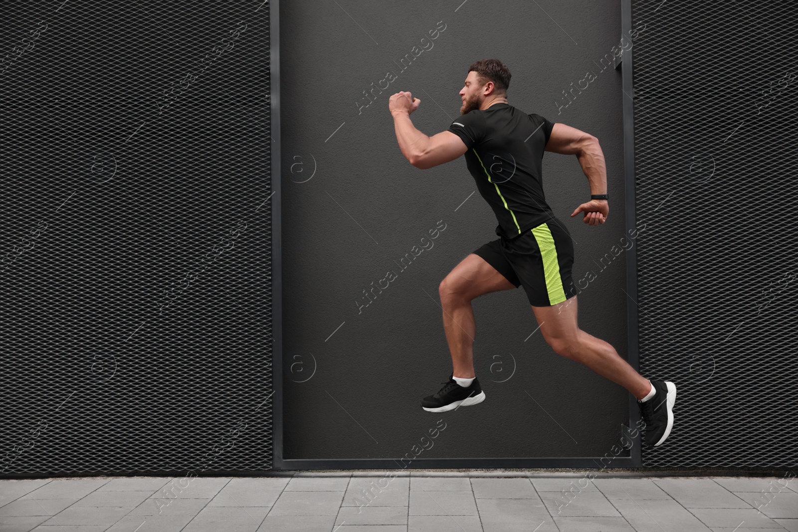 Photo of Young man running near building outdoors. Space for text