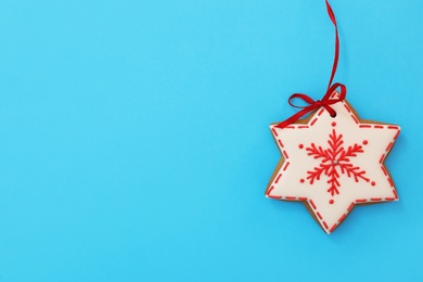 Photo of Snowflake shaped Christmas cookie on light blue background, top view. Space for text