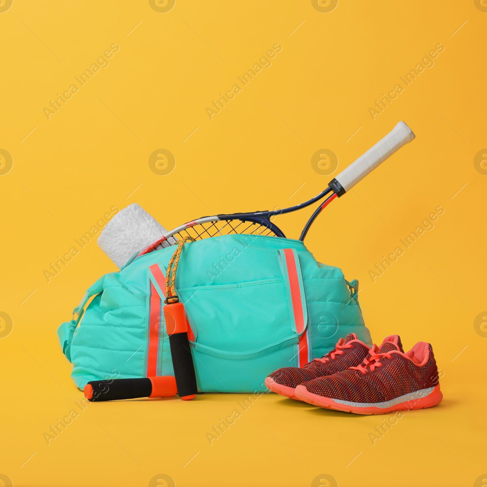 Photo of Blue gym bag and sports accessories on yellow background