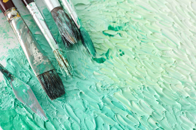 Photo of Abstract colorful artwork and brushes, closeup view