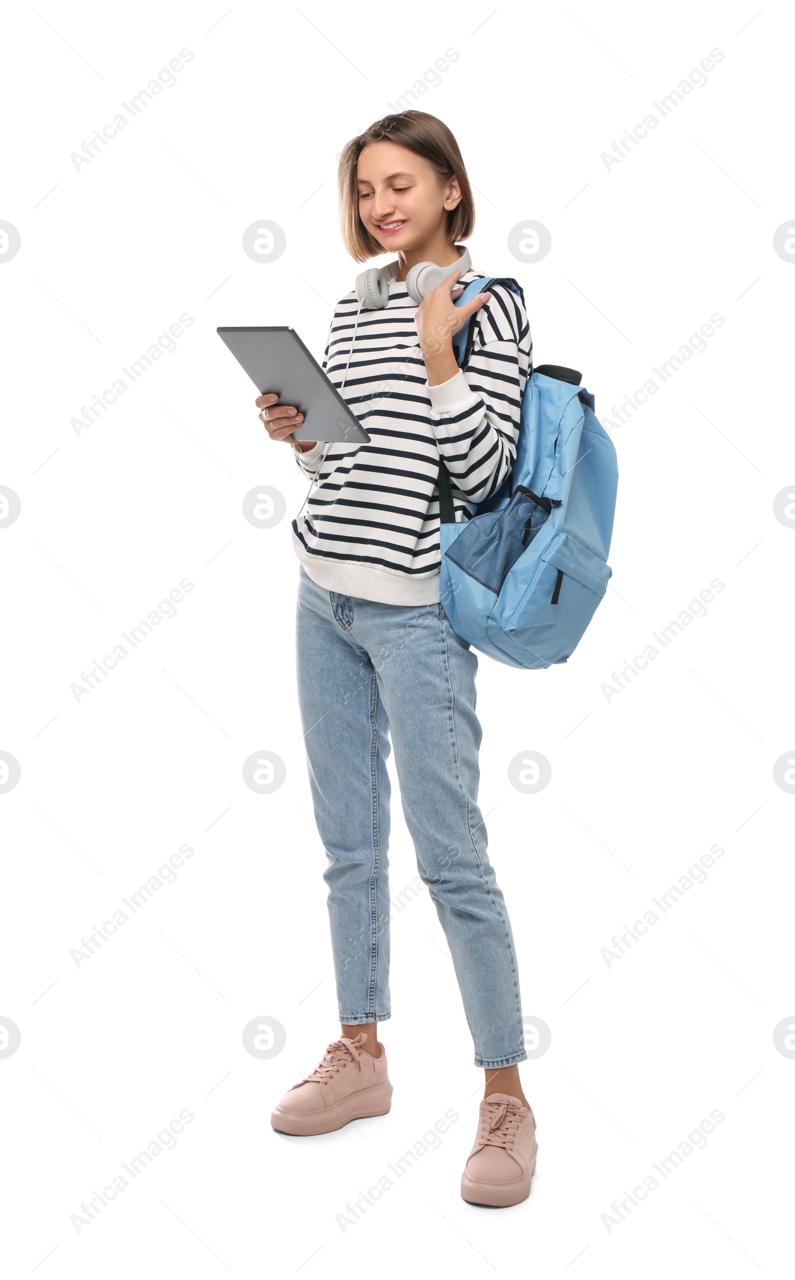 Photo of Young student with tablet, backpack and headphones on white background