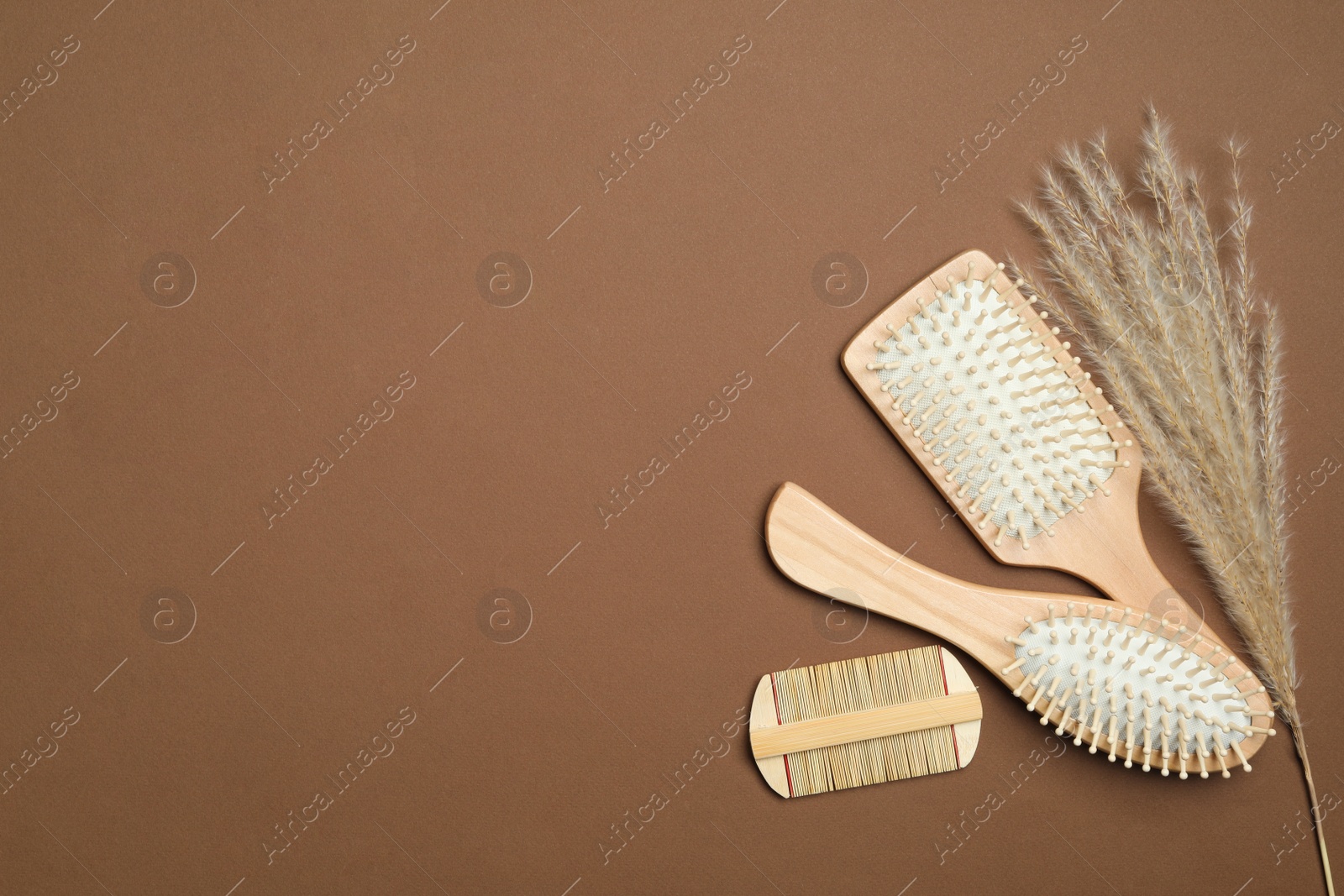 Photo of Flat lay composition with modern hair comb and brushes on brown background. Space for text