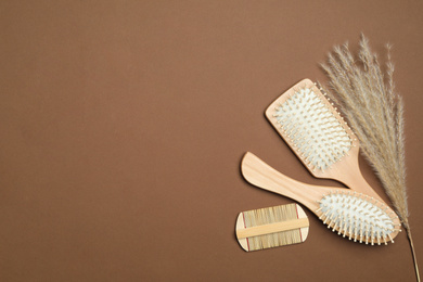 Photo of Flat lay composition with modern hair comb and brushes on brown background. Space for text