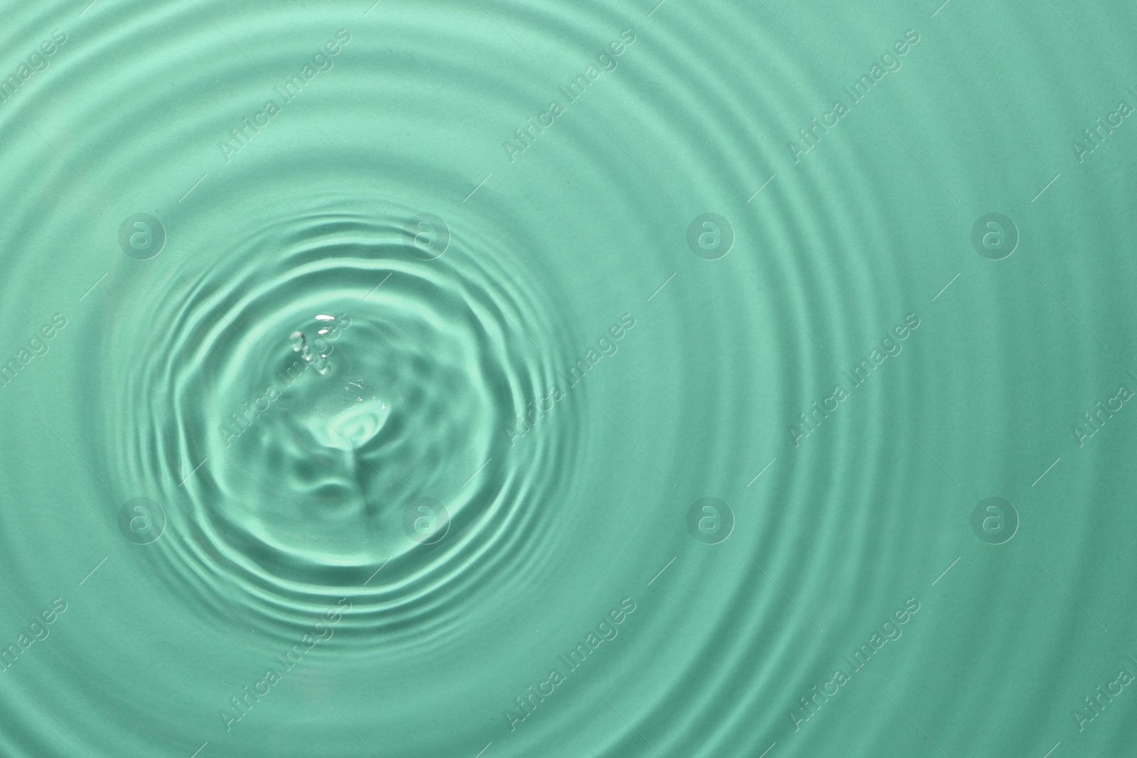 Image of Rippled surface of clear water on green background, top view