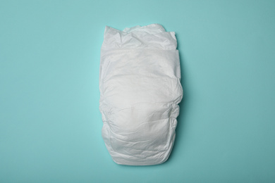 Photo of Baby diaper on light blue background, top view