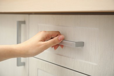 Woman opening drawer at home, closeup view