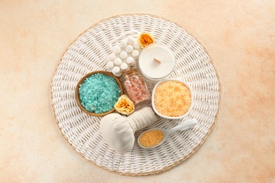 Photo of Aromatic sea salt, beautiful flowers and different spa products on color textured table, flat lay
