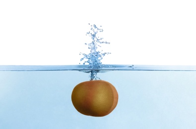 Photo of Grapefruit falling down into clear water against white background