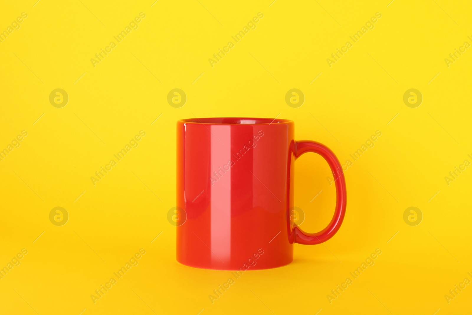 Blank red ceramic mug on yellow background Photo of Blank red ceramic mug on yellow background