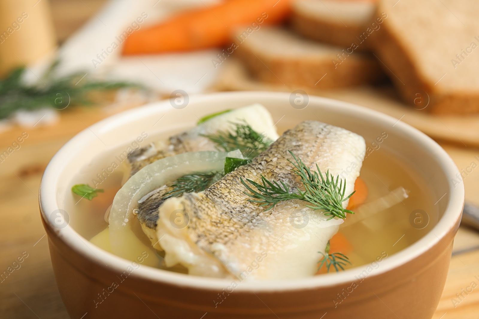 Photo of Delicious fish soup in bowl on table, closeup view