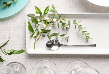 Stylish tableware with leaves on table, flat lay. Festive setting