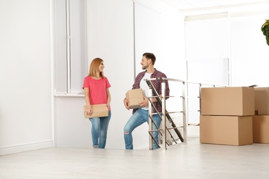 Photo of Couple with moving boxes in their new house