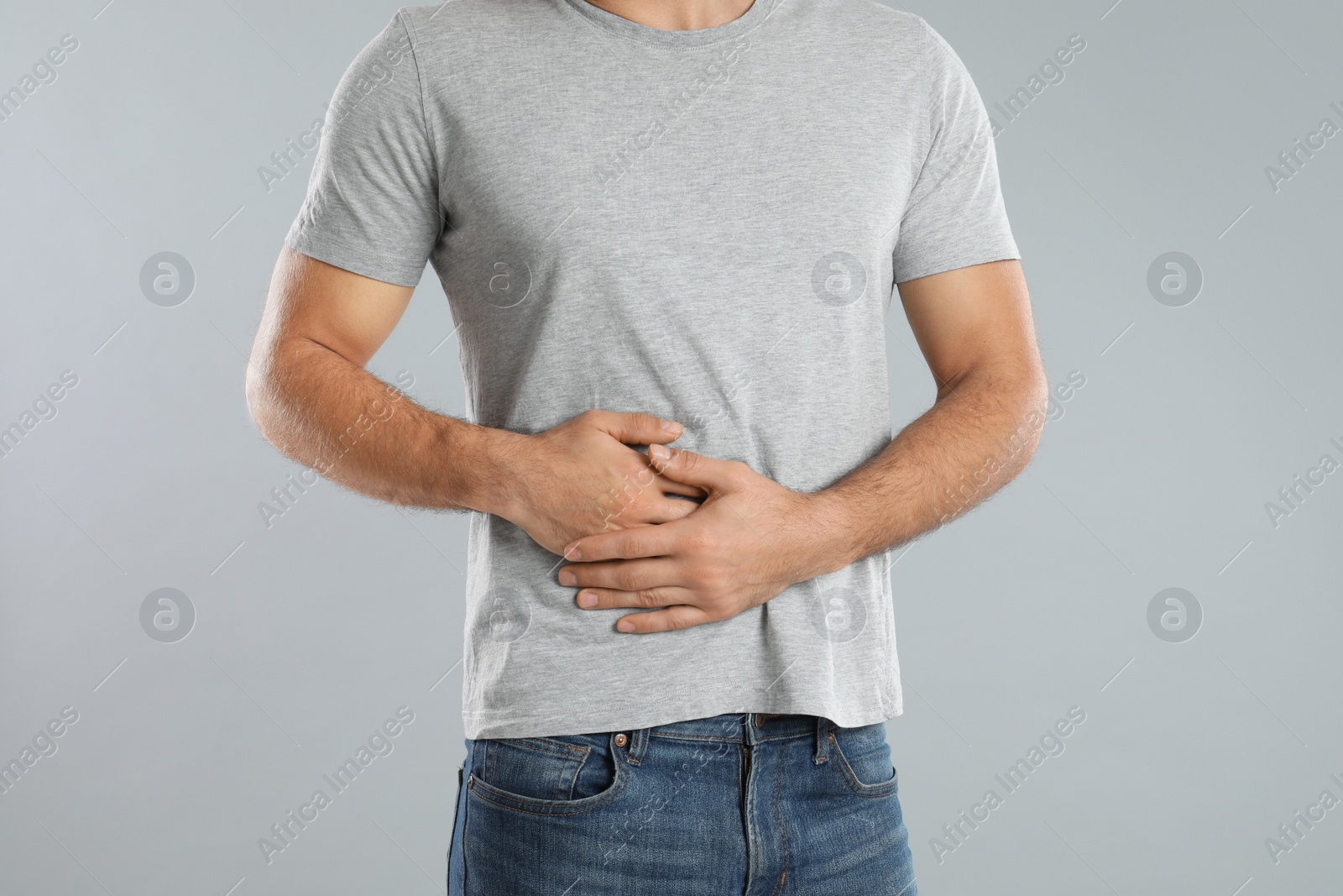 Photo of Man suffering from liver pain on grey background, closeup