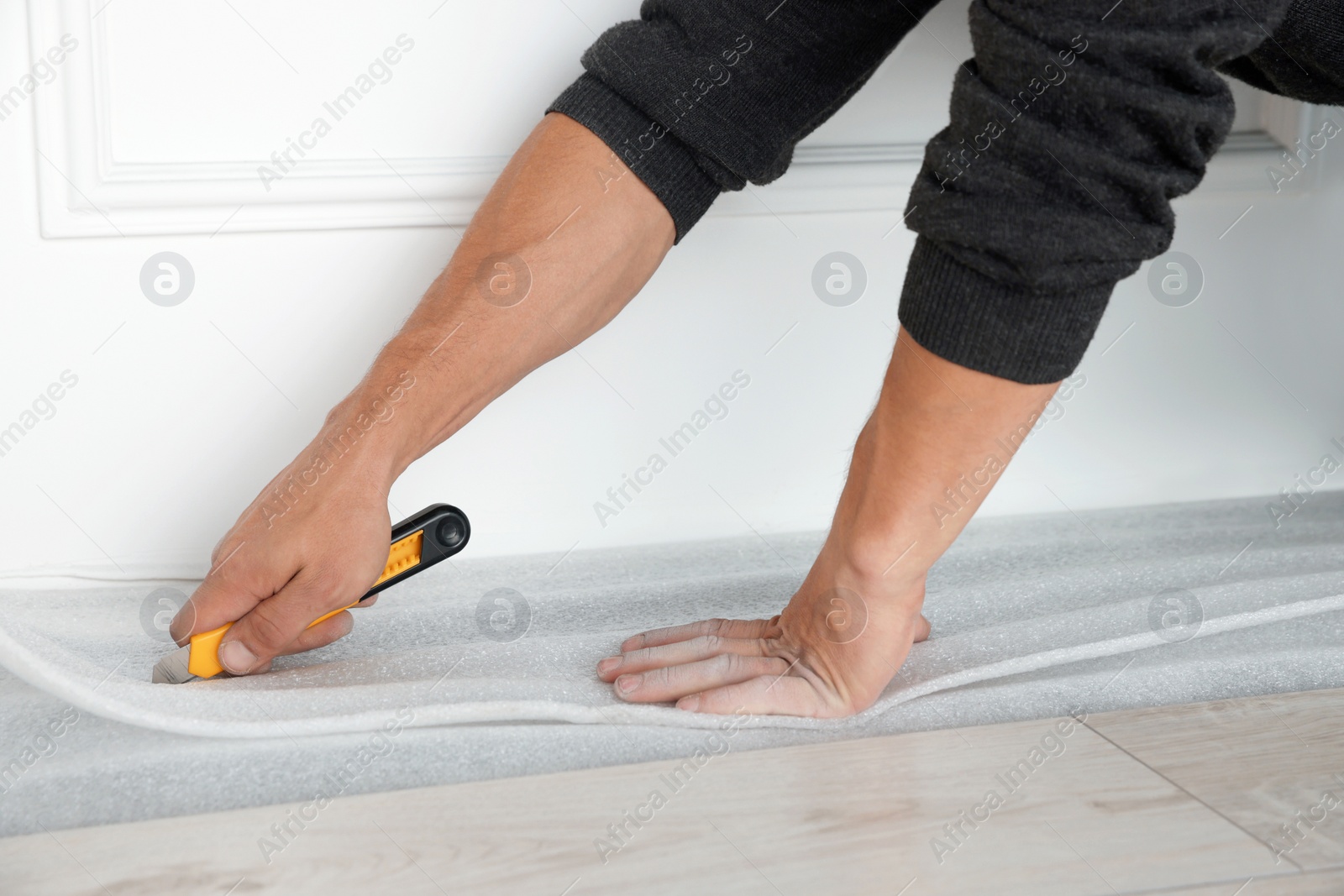 Photo of Worker installing new laminate flooring in room, closeup