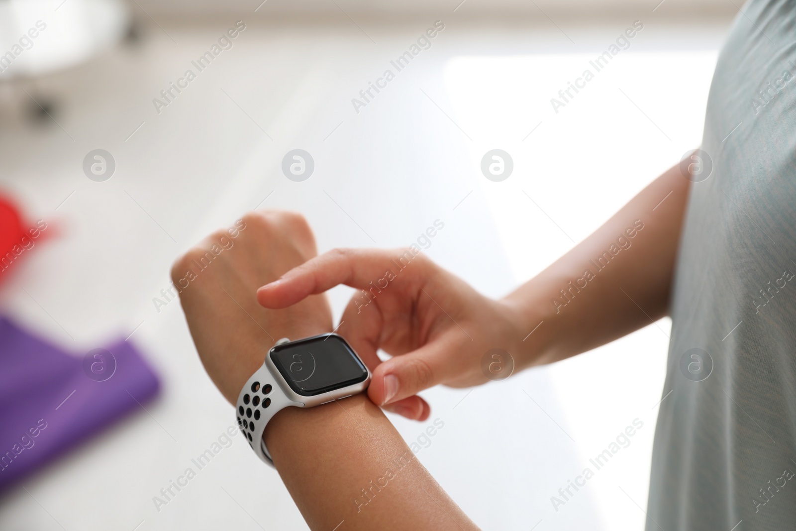 Photo of Woman checking fitness tracker in gym, closeup