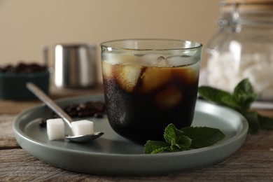 Delicious iced coffee in glass on wooden table, closeup