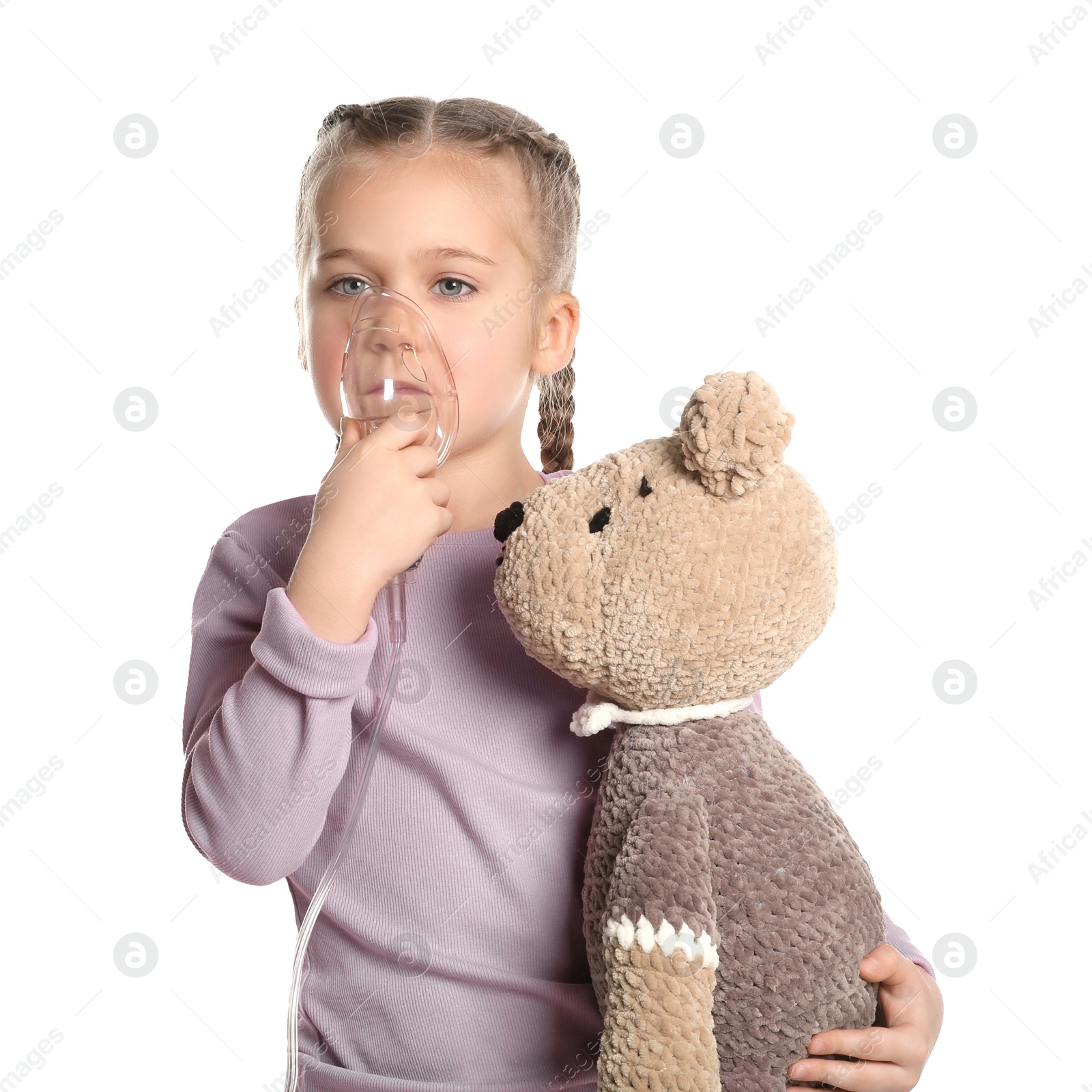 Photo of Little girl with toy bear using nebulizer for inhalation on white background