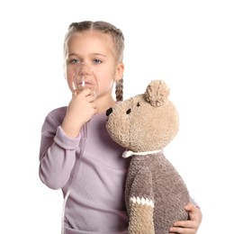 Photo of Little girl with toy bear using nebulizer for inhalation on white background