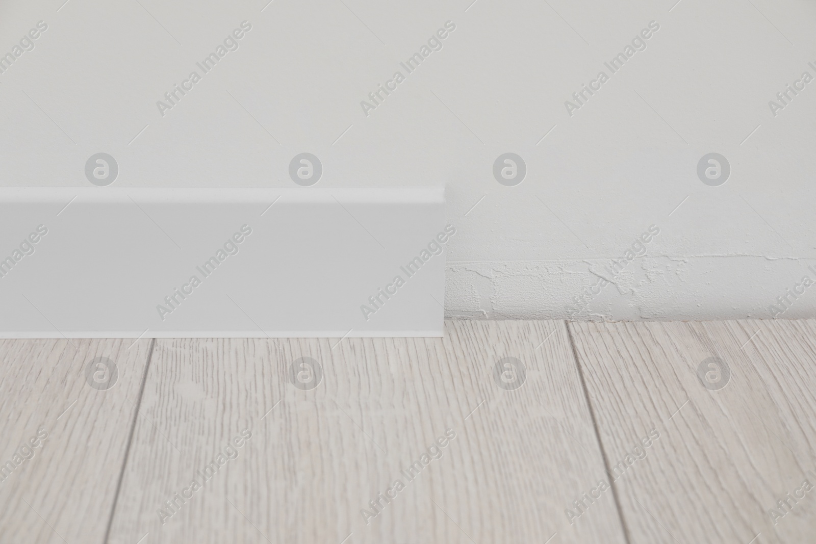 Photo of White plinth on laminated floor in room