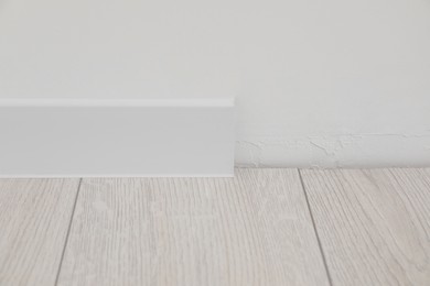 White plinth on laminated floor in room