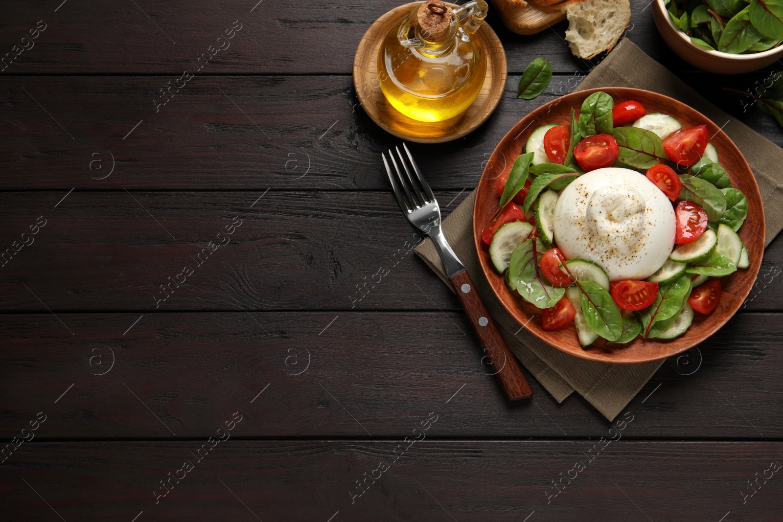 Photo of Delicious burrata salad served on wooden table, flat lay. Space for text