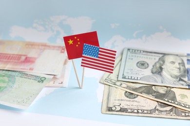 Photo of Banknotes, American and Chinese flags on world map. Trade war concept