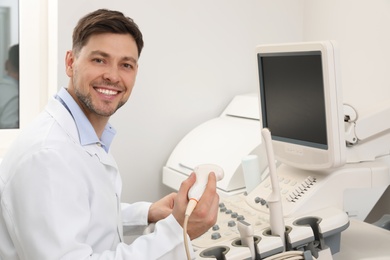 Sonographer operating modern ultrasound machine in clinic