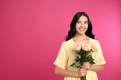 Portrait of smiling woman with beautiful bouquet on pink background. Space for text