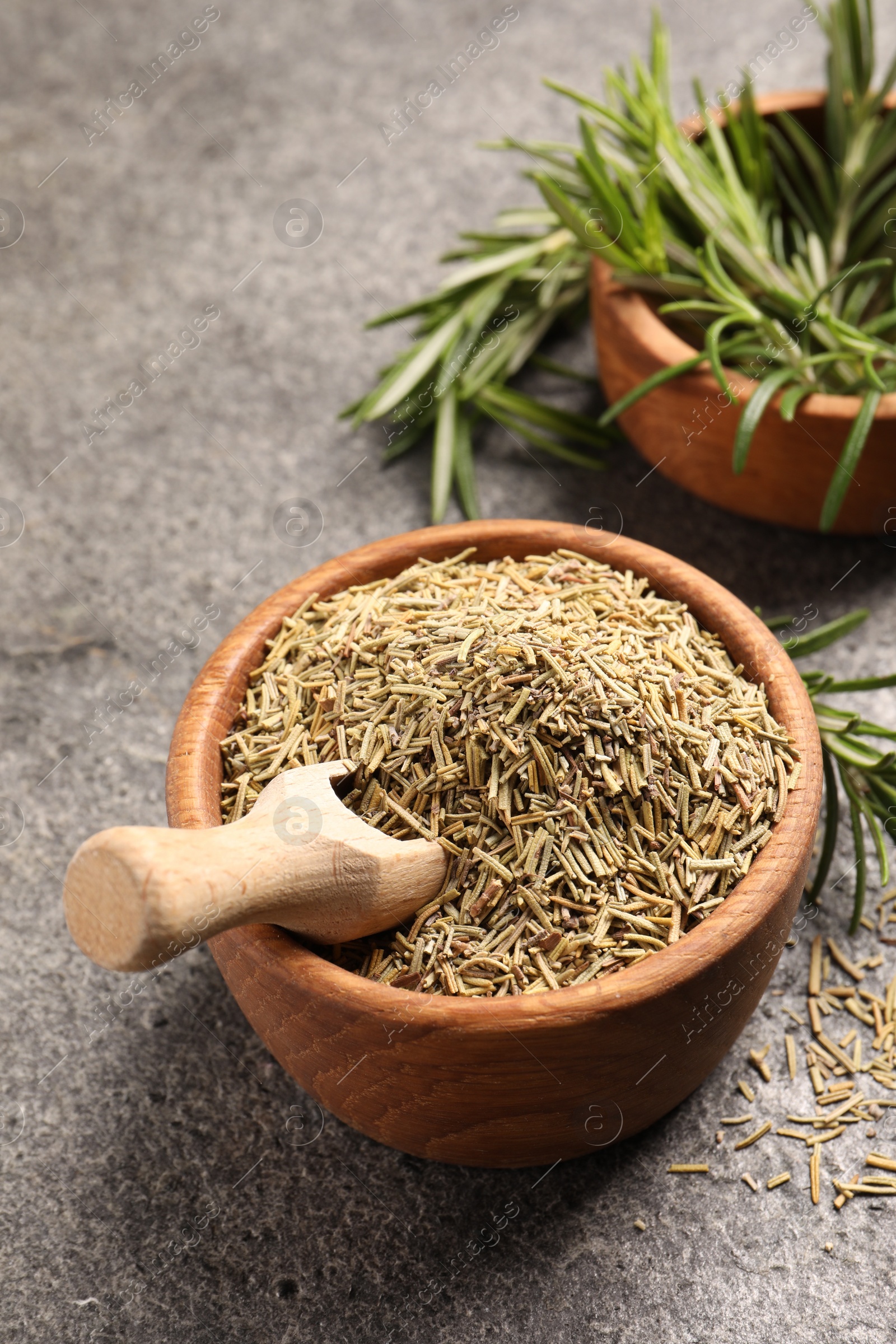 Photo of Bowls with fresh and dry rosemary on grey table