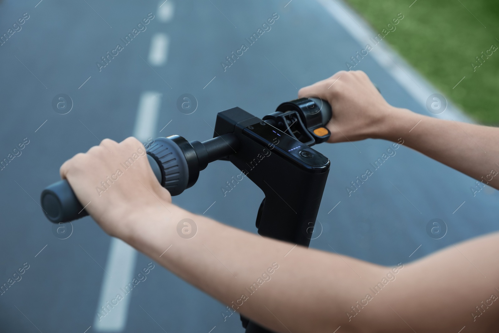 Photo of Woman with modern electric kick scooter outdoors, closeup