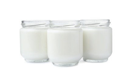 Photo of Glass jars with delicious homemade yogurt on white background