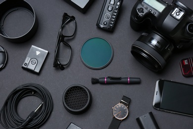 Photo of Flat lay composition with equipment for professional photographer on dark background