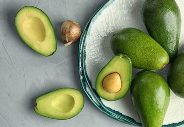 Flat lay composition with ripe avocados on grey background