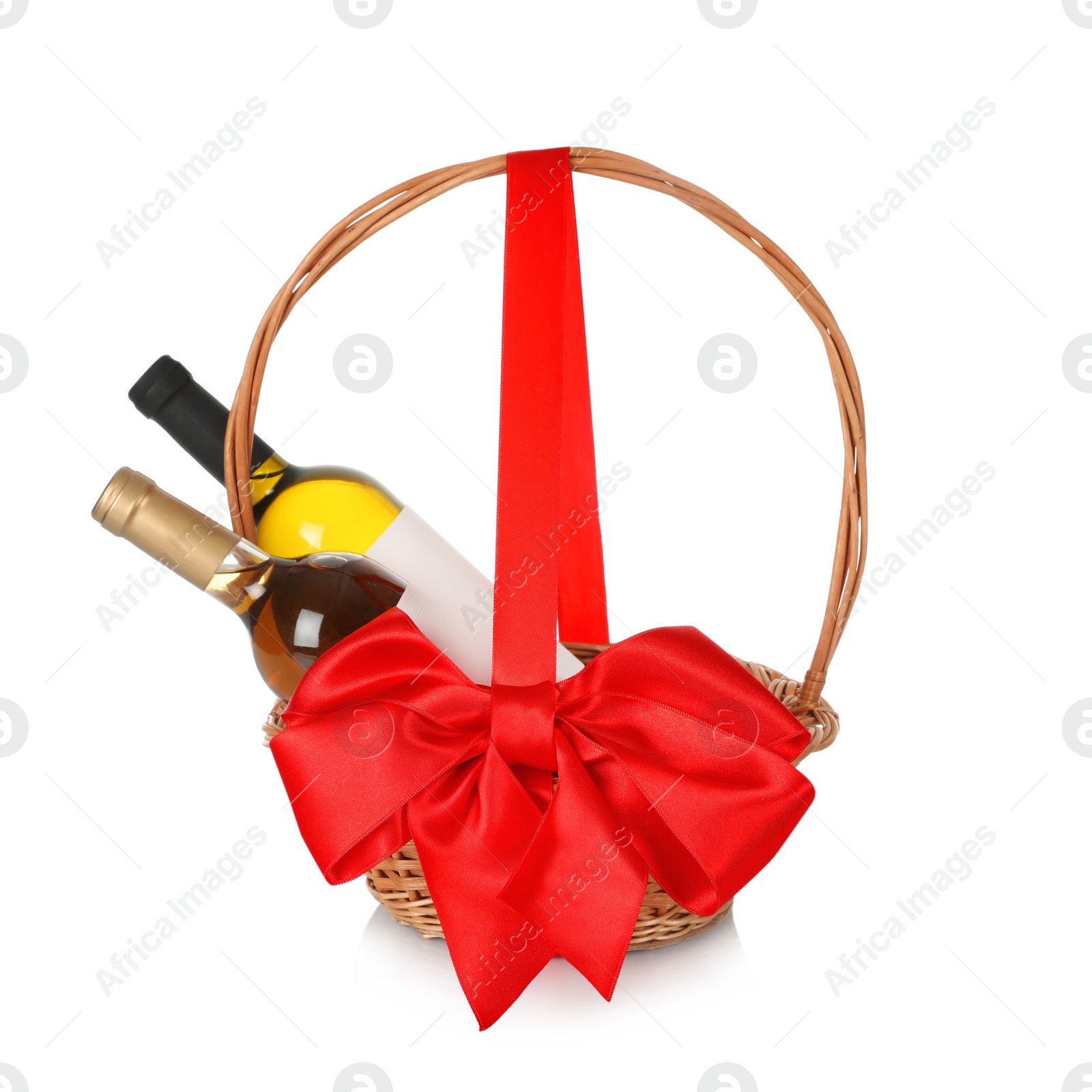 Photo of Bottles of wine in wicker basket with red bow isolated on white