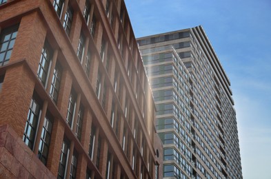 Exterior of beautiful modern skyscrapers against blue sky, low angle view