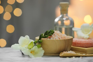 Beautiful composition with different spa products and flowers on white marble table against blurred background. Space for text