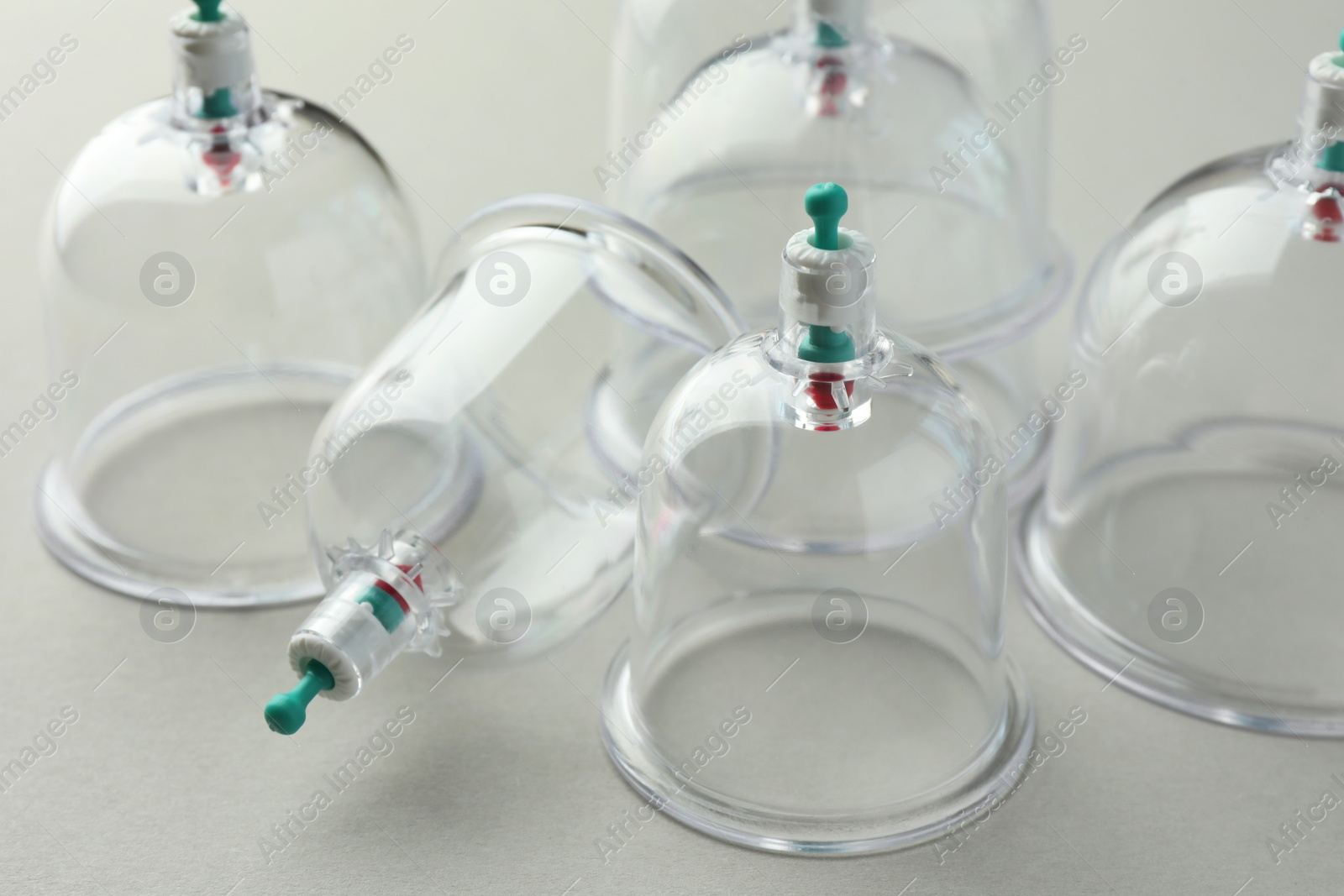 Photo of Plastic cups on light grey background, closeup. Cupping therapy