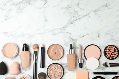 Photo of Flat lay composition with skin foundation, powder and beauty accessories on marble background. Space for text